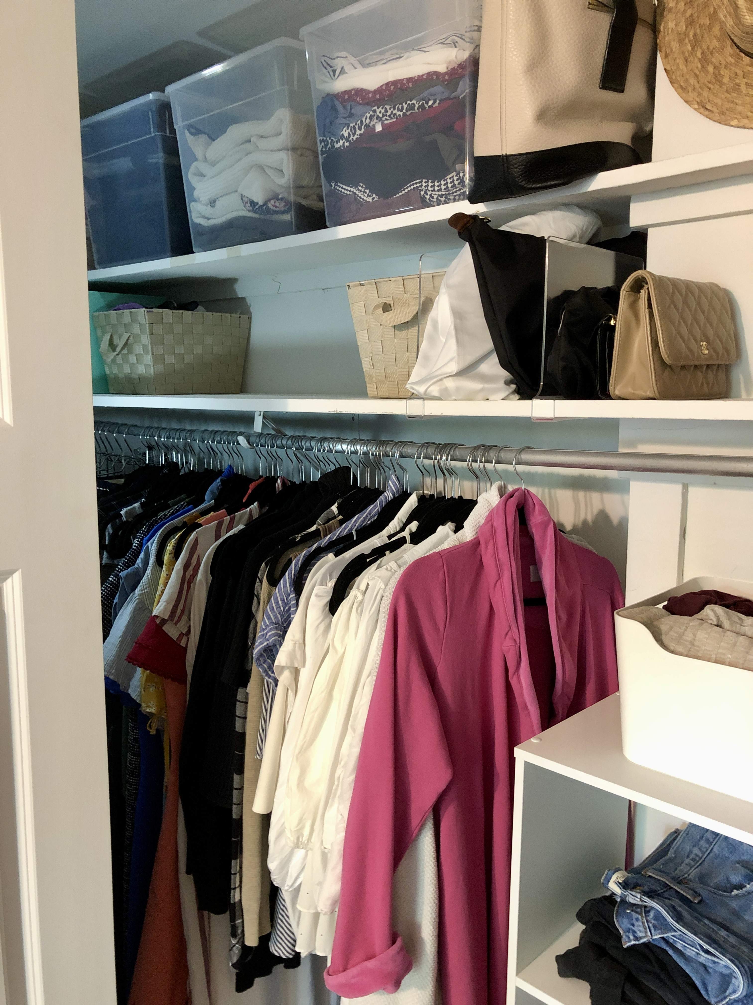 Clear containers hold off-season clothing on top shelves