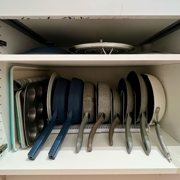 Frying pans are organized vertically using the YouCopia Expandable Cookware Organizer.